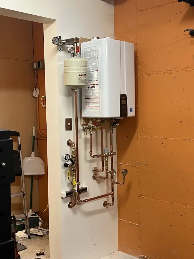 Plumbing technician inspecting water heater connections in Warrington